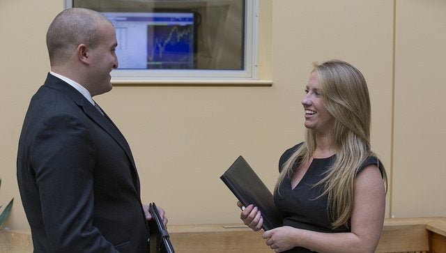 Two adults dressed in business attire talking