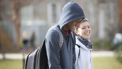 Two students talking while walking on the Kingston campus