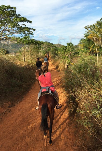 students riding horses in Cuba