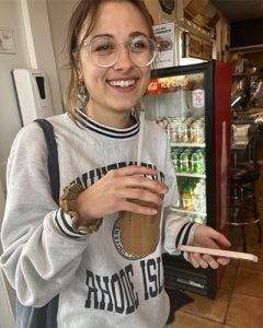 Madeline drink coffee wearig a uri sweatshirt after finishing her junior year