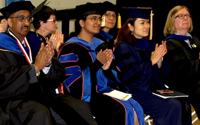 faculty members clapping during graduation ceremony