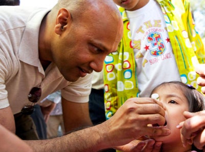 health worker giving a child an oral vaccine