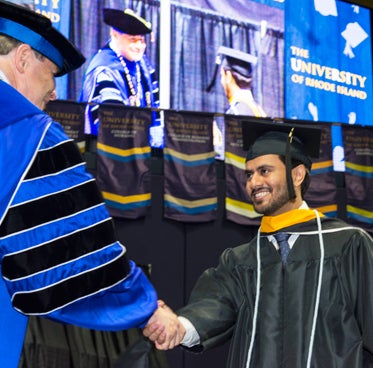 graduate student shaking hands with President Dooley