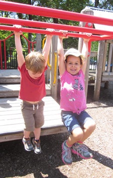 two children hanging on the CDC playground