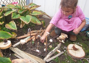 child playing with sticks and dirt