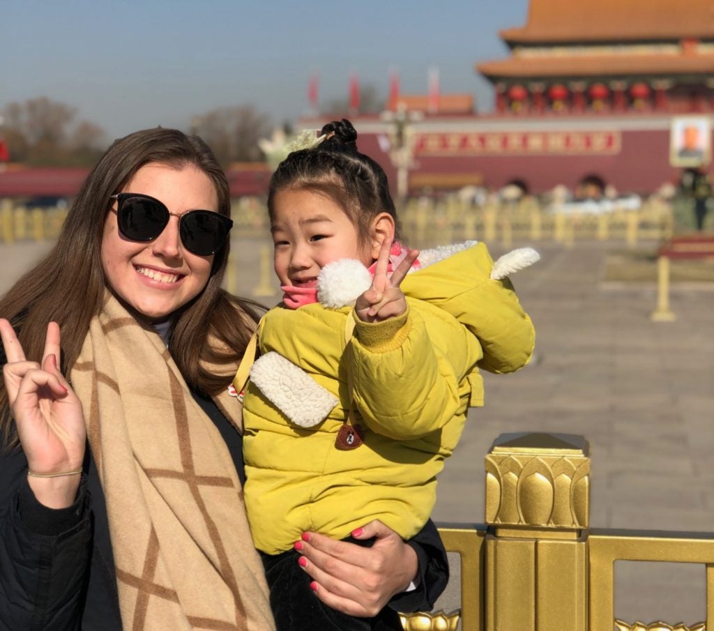Emily Hadfield poses with a small child during her Capstone Year in China