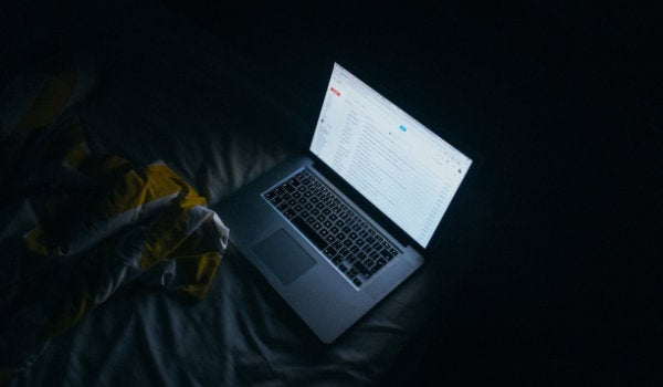 a person using a laptop in the dark