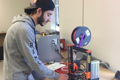 a student operating a 3D printer
