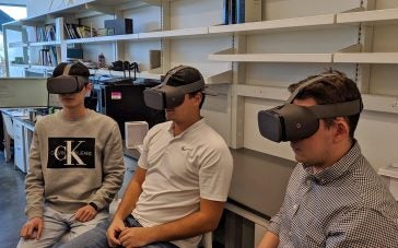 Graduate students Jiangong Chen, Matthew Constant and Noah Johnson wearing Google Daydream headsets in Bin Li's lab.
