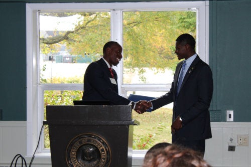 Students shaking hands at a podium during a Society of Black Engineers event