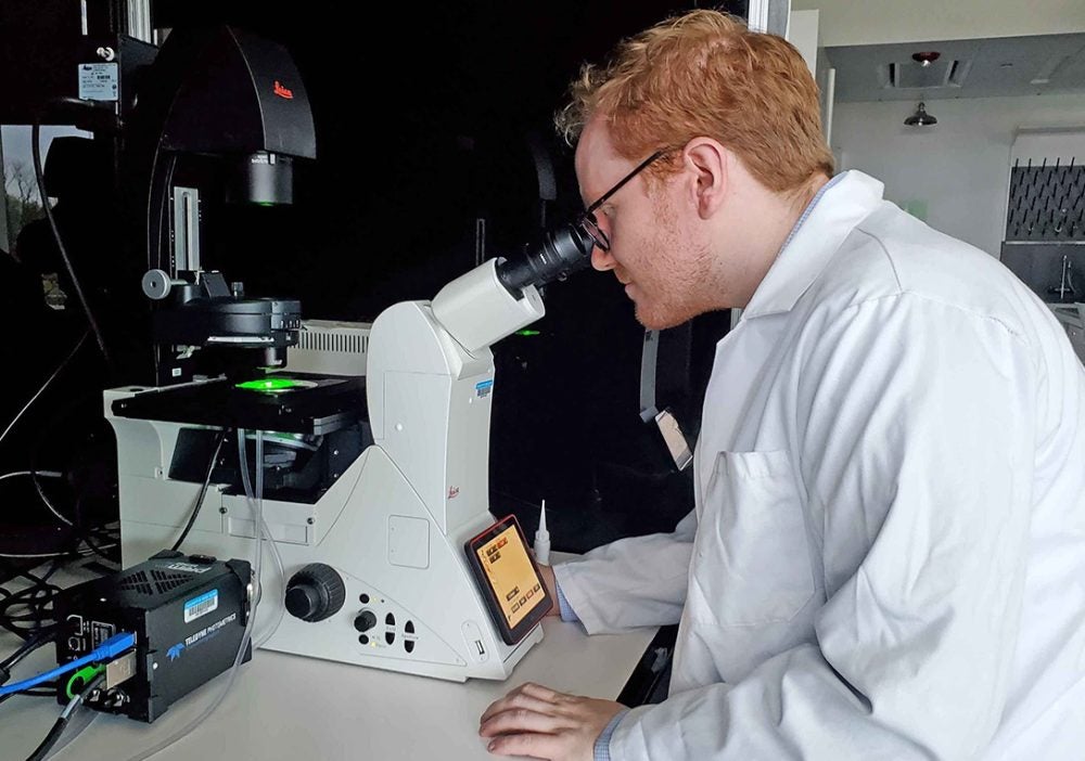 Ryan Poling-Skutvik using a fluorescence microscope to investigate the behavior of responsive emulsions. 