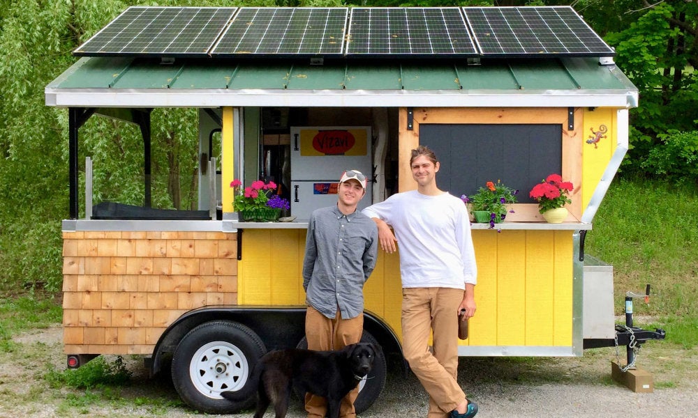 URI civil engineering alumnus Matthew Fuller and fellow URI alumnus Justin Bristol in front of one of their solar-powered food cart designs