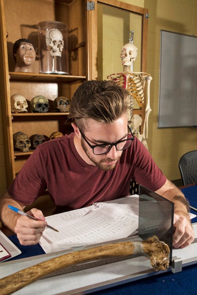 student measuring a bone in lab