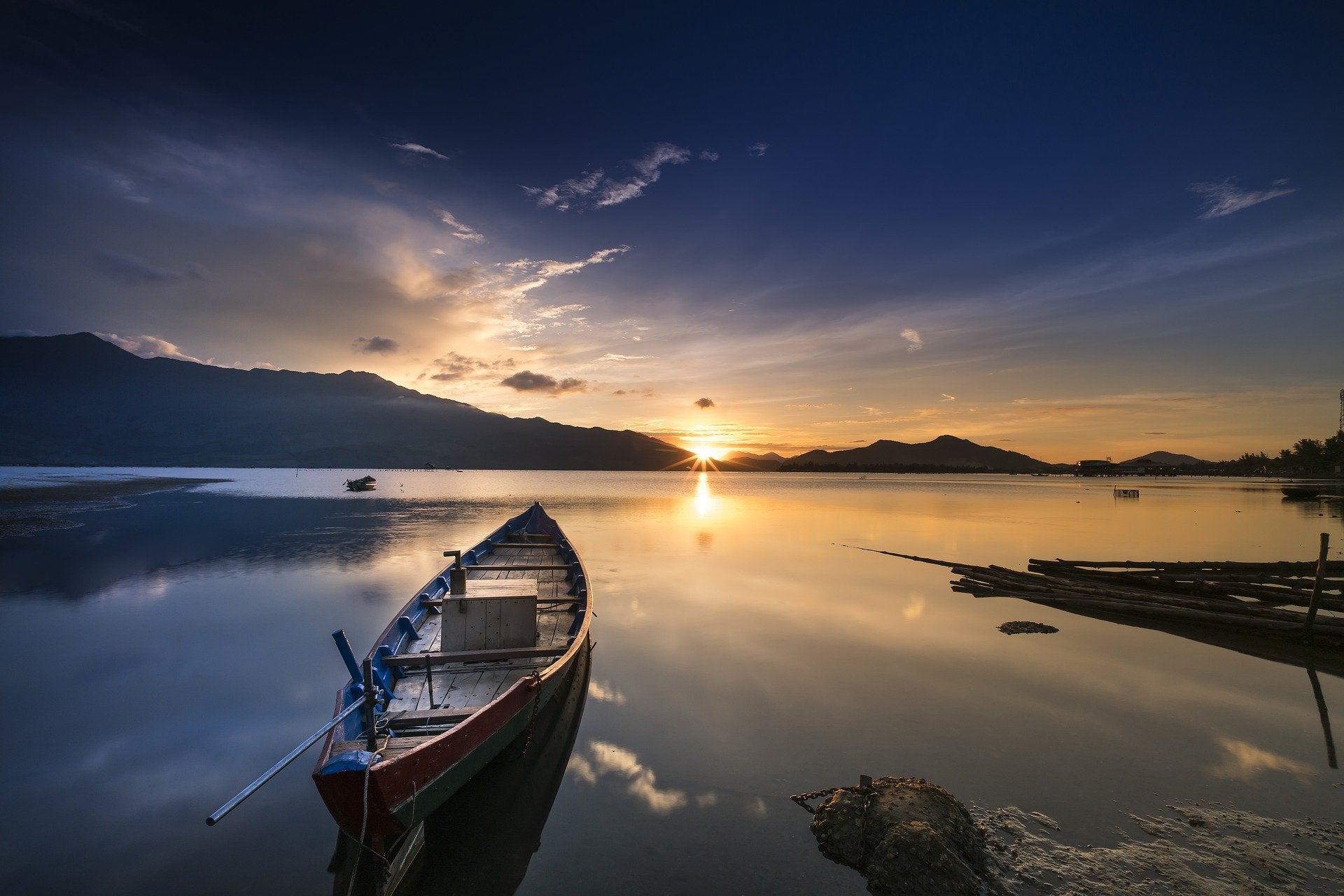 Row boat on water with sun rising