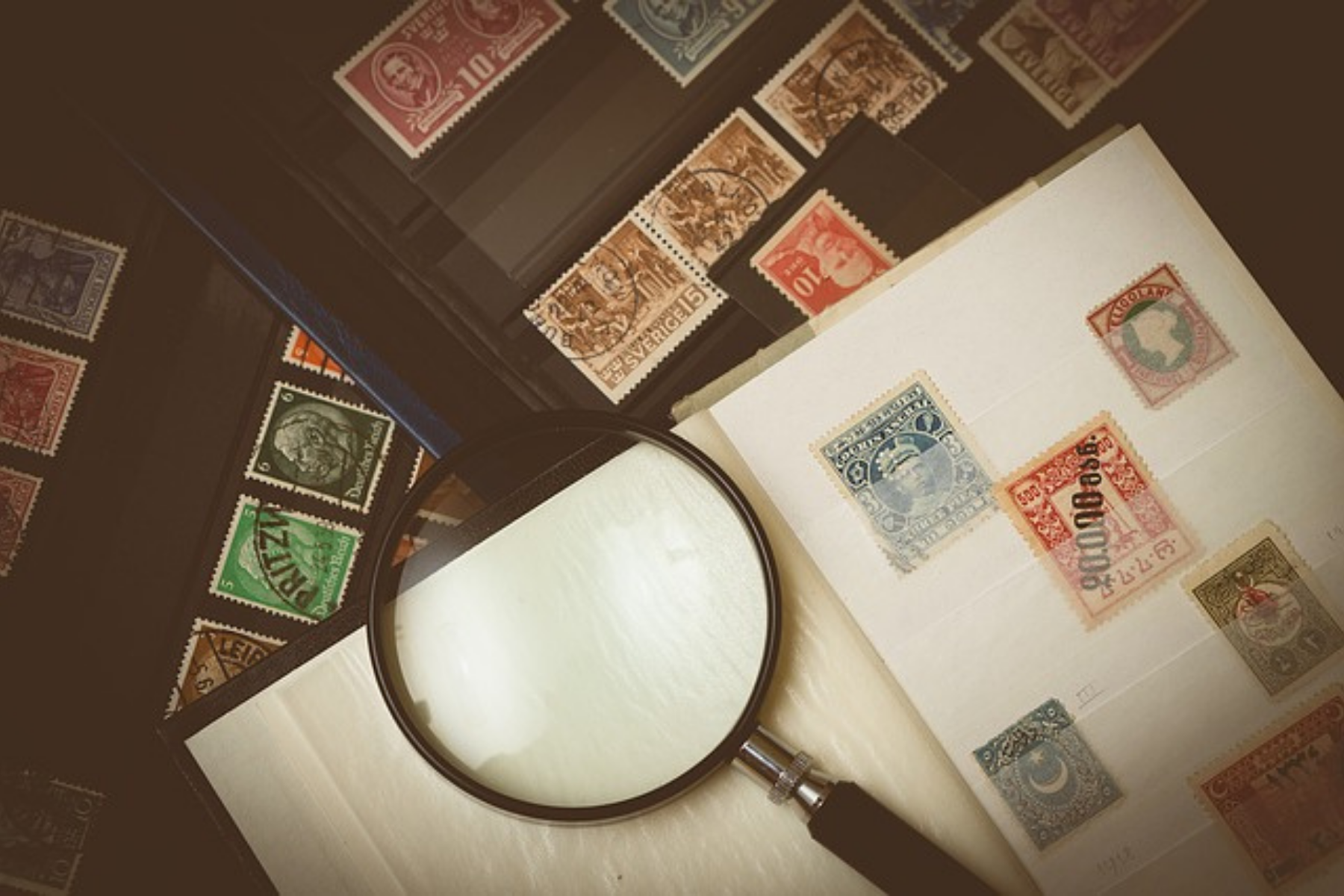 Magnifying glass on paper with stamps