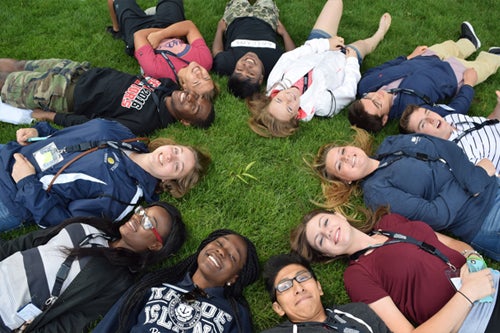 Students lying in a circle on the quad
