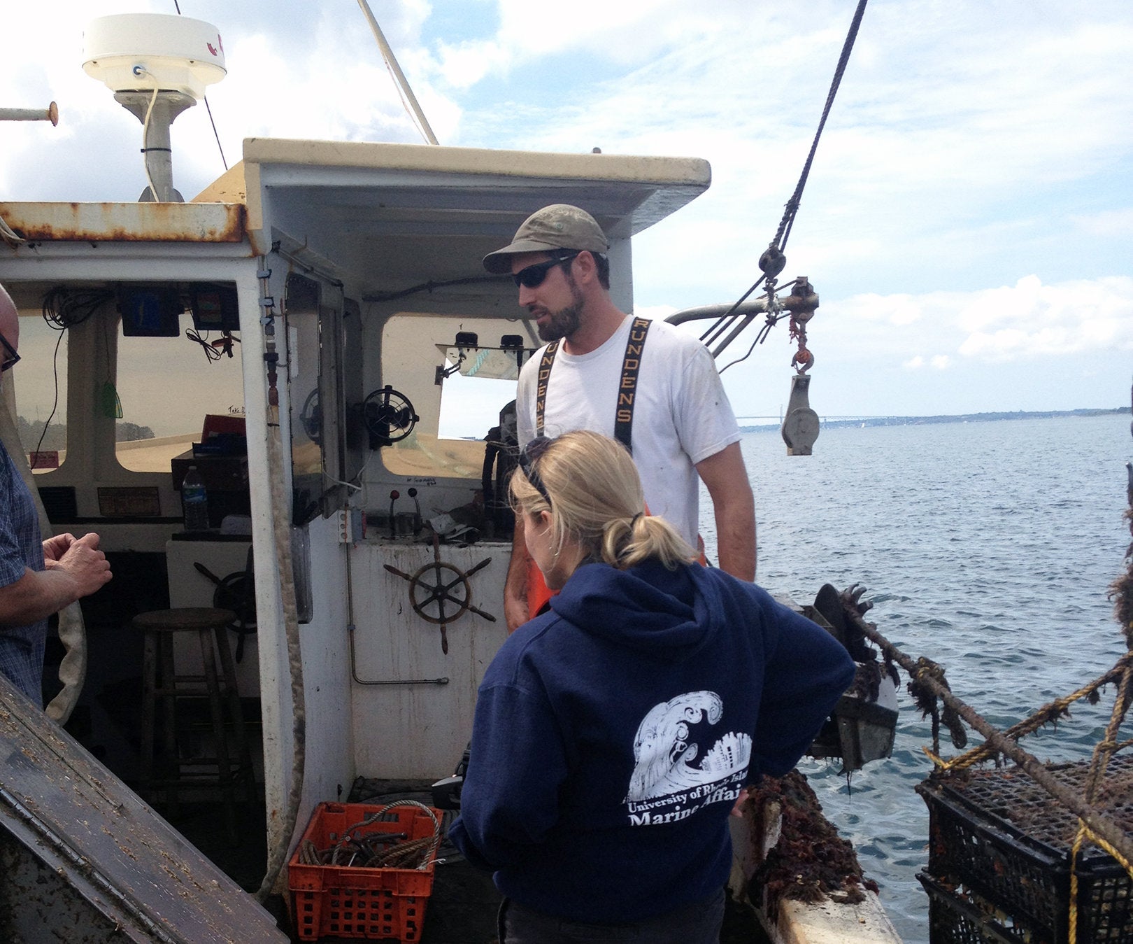 Tracey Dalton, professor and chair of the department of Marine Affairs, lends a hand on board an aquaculture vessel in Narragansett Bay.