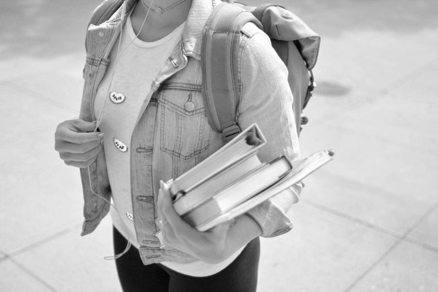 A student wearing a backpack and jean jacket