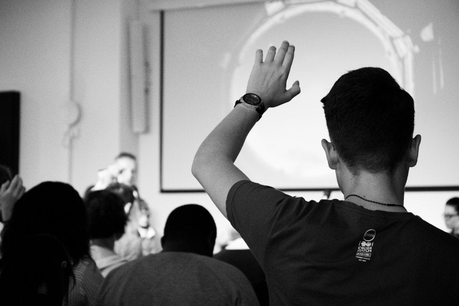 A person raising their hand during a lecture class