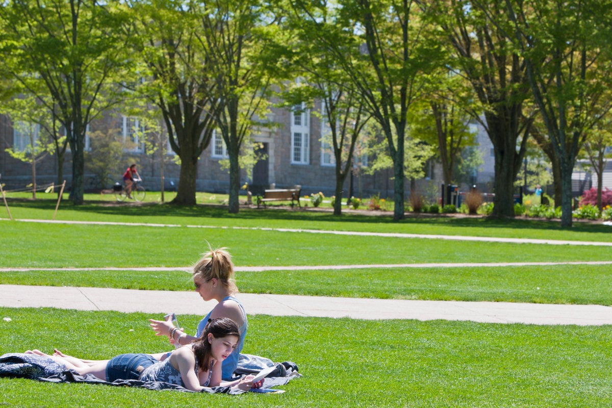 Two students relax on a sunny day on the Quadrangle of the URI Kingston Campus