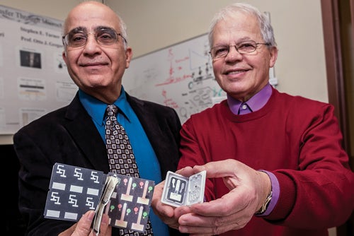 URI engineering professors Mohammad Faghri (left) and Constantine Anagnostopoulos pose with their lab-on-paper technology for medical diagnostics.