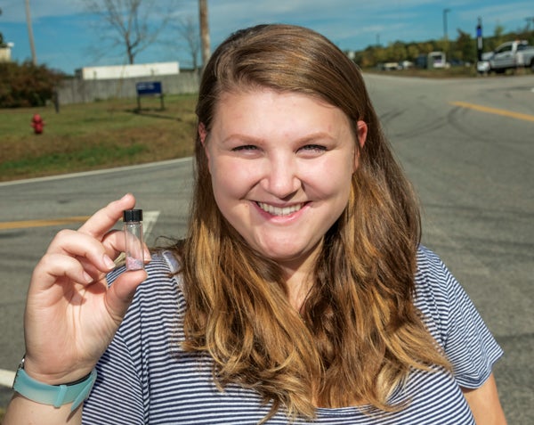 Tabatha Lewis, a URI senior majoring in environmental science, holds a container of microbeads.