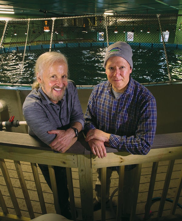 URI Fisheries Professor Terry Bradley, M.S. ‘79, at left, with aquaculture entrepreneur Peter Mottur ‘91 at their yellowfin tuna research facility on the Narragansett Bay Campus. 