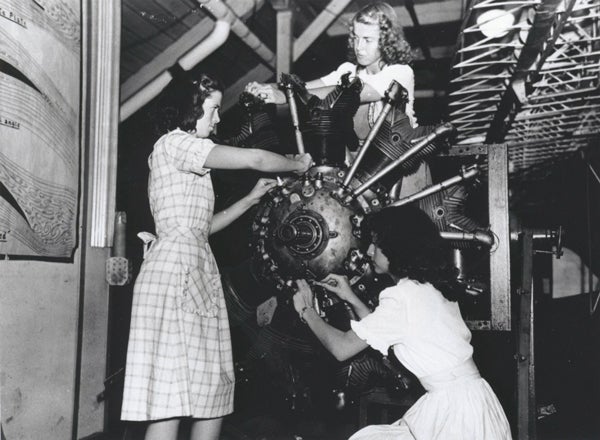 Vintage photo of female studentsworking on an airplane.