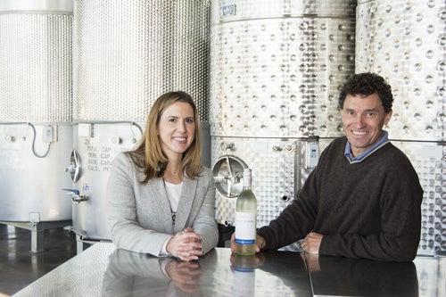 Cassandra Earle ‘04, Newport Vineyards marketing director, and co-owner John Nunes ‘88, at the tasting bar that faces the winery’s massive fermentation tanks. 