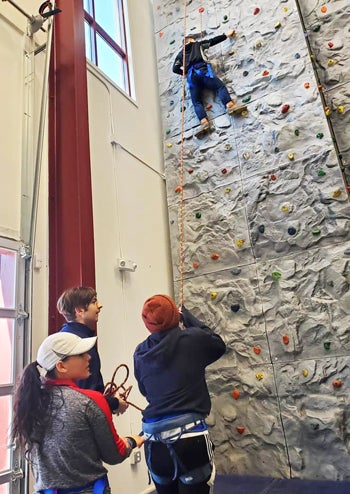 students training on a climbing wall
