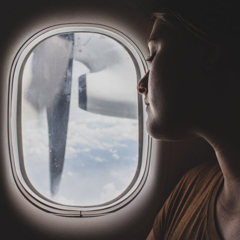 A woman looking out an airplane window. Photo by Ethan Sykes on Unsplash