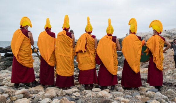 Monks performing a musical ceremony at the beach during the closing of the symposium on nonviolence