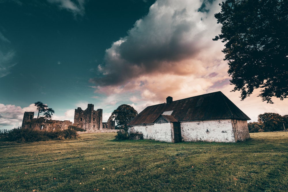 A dramatic Irish landscape with whitewashed farm house