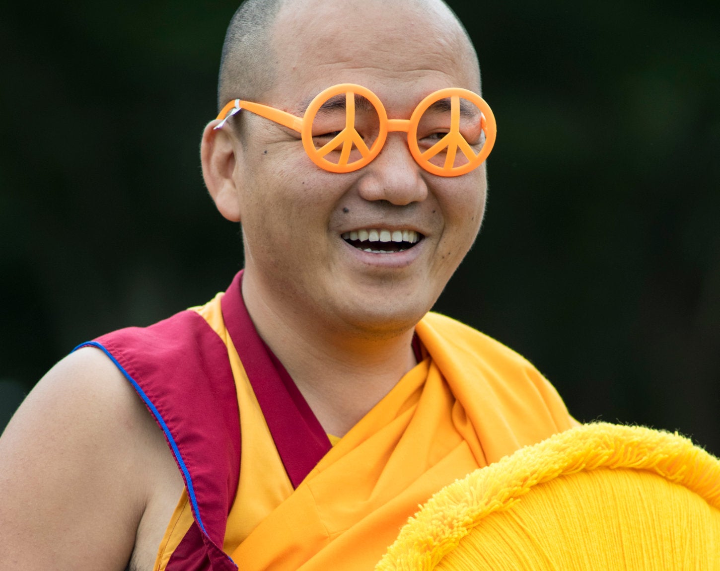 A monk wearing peace-shaped glasses at a campus peace event