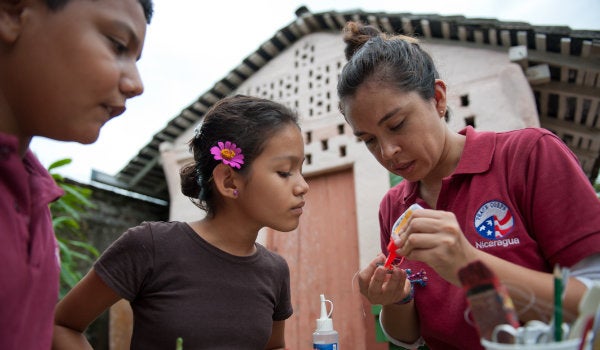 A Peace Corps volunteer in Nigaragua works on an art craft with children