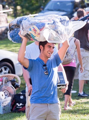 student carrying clothing on move in day