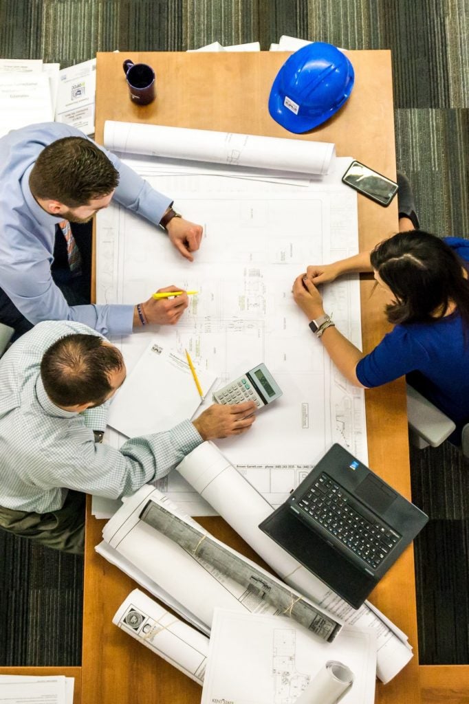 people sitting around table reviewing site plans