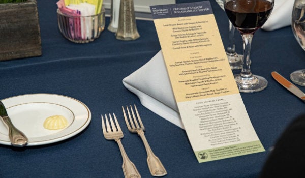 A place setting at a sustainability supper event with detailed menu about the food and its careful sourcing