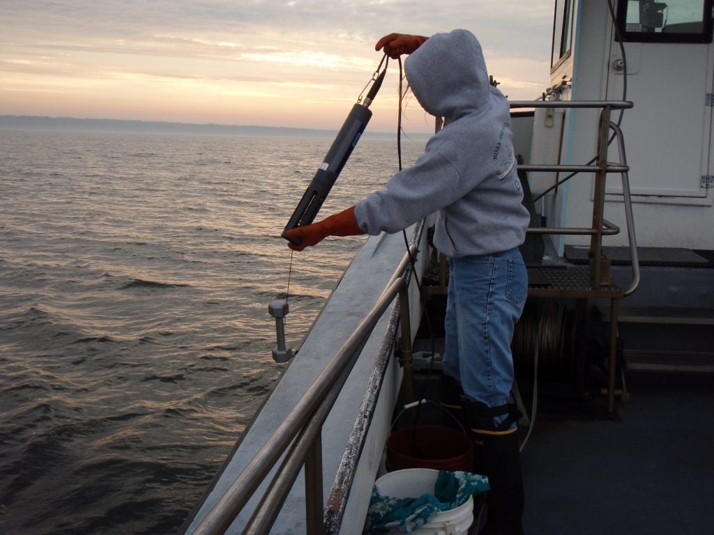 A student deploys the YSI multi-parameter sonde to measure water quality. Photo credit J. Danforth.