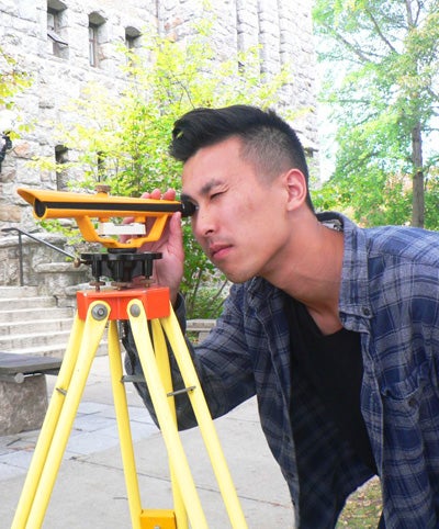 student using scope for surveying