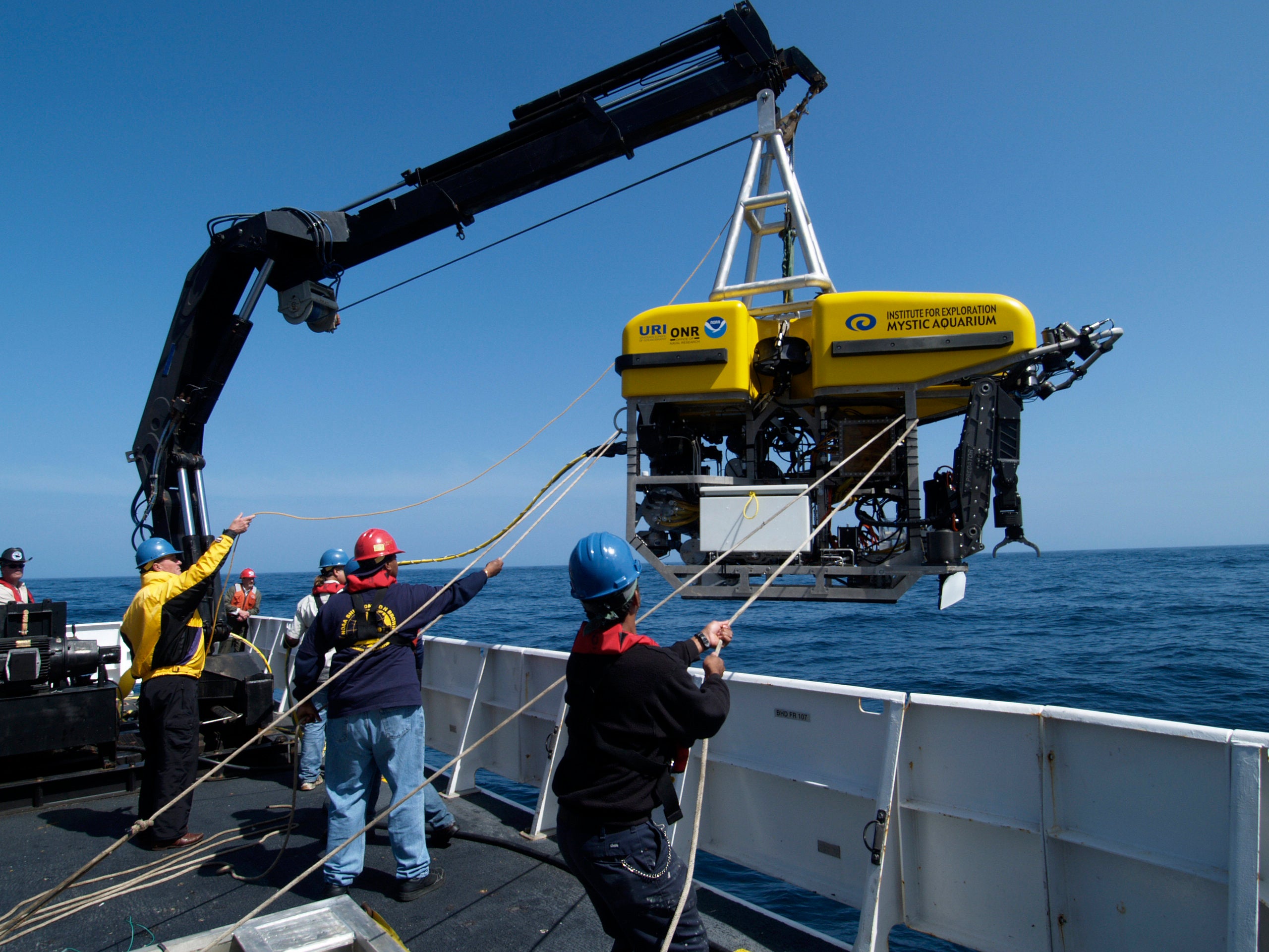 A ship’s crew prepares an underwater drone.