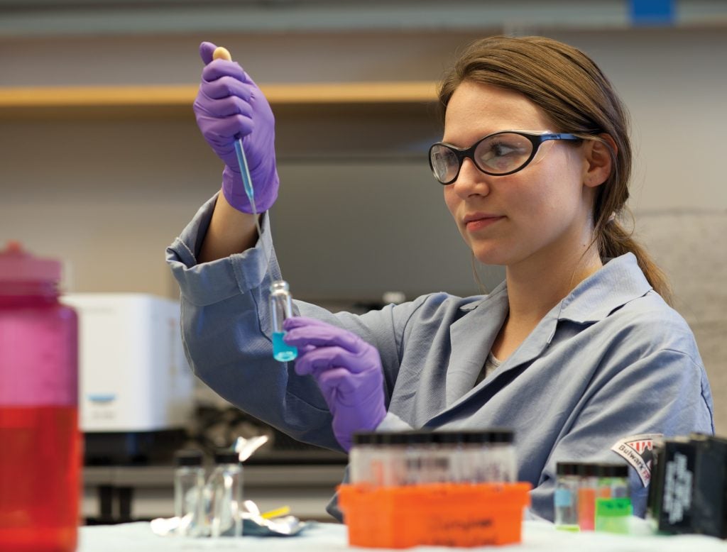 URI student Dana DiScenza measuring liquids from commercial containers to determine if packaging chemicals were found in the fluids