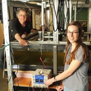Christopher Kincaid, a professor at the Graduate School of Oceanography, and Loes van Dam, a graduate student, stand next to a corn-syrup filled apparatus to conduct experiments tectonic plates. Photo by Randy Osga.