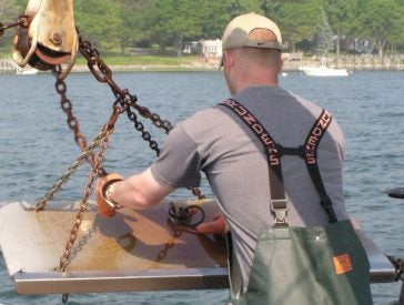 A student attaches the hang-chain to the starboard side trawl door (otter board) after a tow.