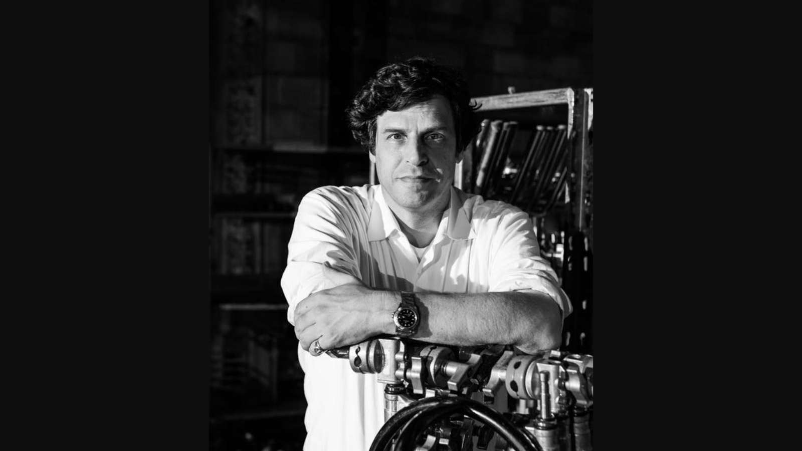 Black and white headshot of Anthony Geffen standing with film equipment.