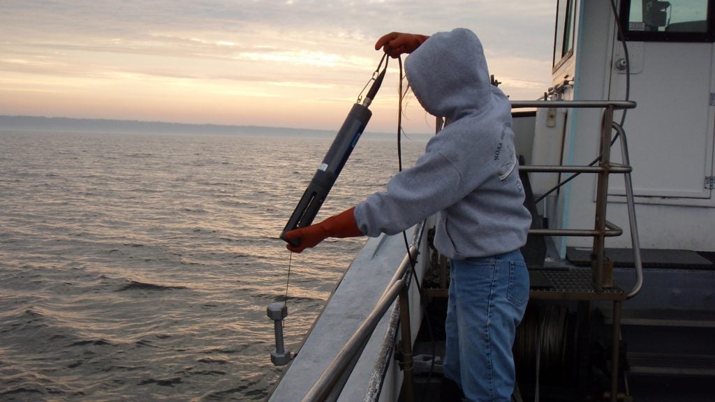 A student deploys the YSI multi-parameter sonde to measure water quality. Photo by J. Danforth.