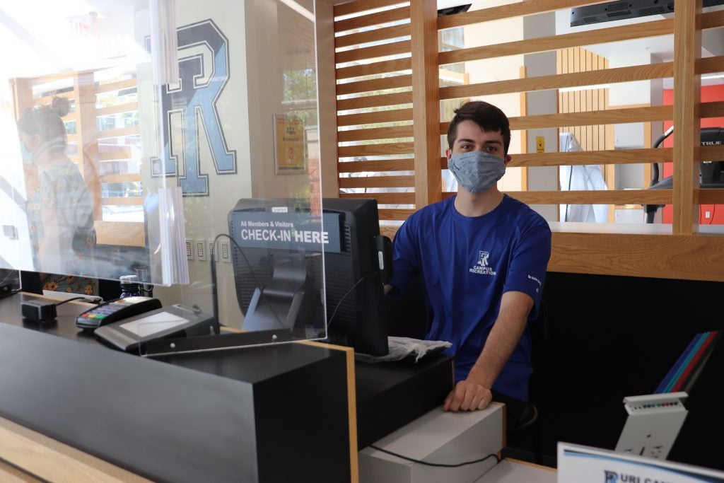campus rec staff members wearing a face mask at the check in counter