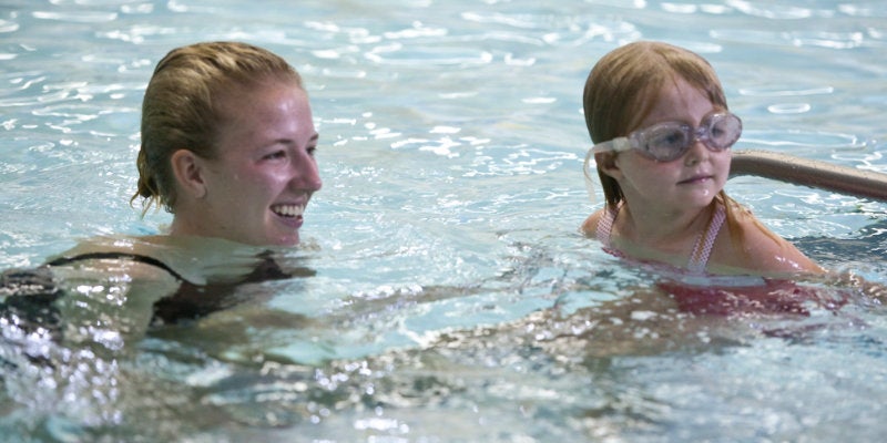 A student working with a teacher during a Learn-to-Swim class