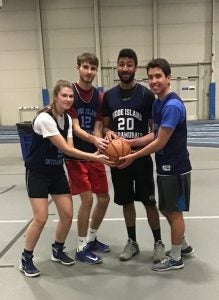 students holding a basketball together on a basketball court
