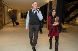 Dr. Paul Farmer and URI College of Nursing Research Assistant Suzy Winchester walk toward his presentation at the R.I. Nec Dec. 12.